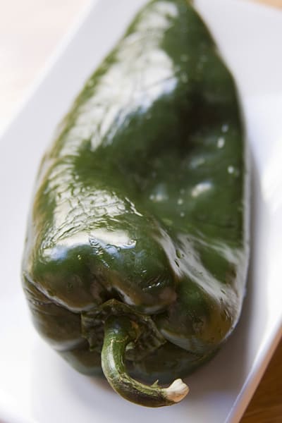 Step-by-step instructions on how to roast poblano peppers using a gas stove, comal or  barbecue grill from theothersideofthetortilla.com