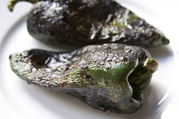 Step-by-step instructions on how to roast poblano peppers using a gas stove, comal or barbecue grill from theothersideofthetortilla.com