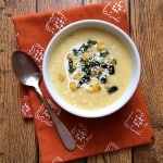 How to make Mexican crema de elote soup, garnished with roasted corn, diced poblano chile, crema mexicana and crumbled cotija cheese. Get more Mexican recipes at theothersideofthetortilla.com.