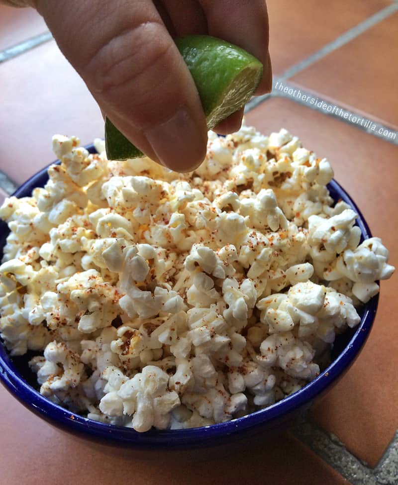 squeezing lime juice over popcorn