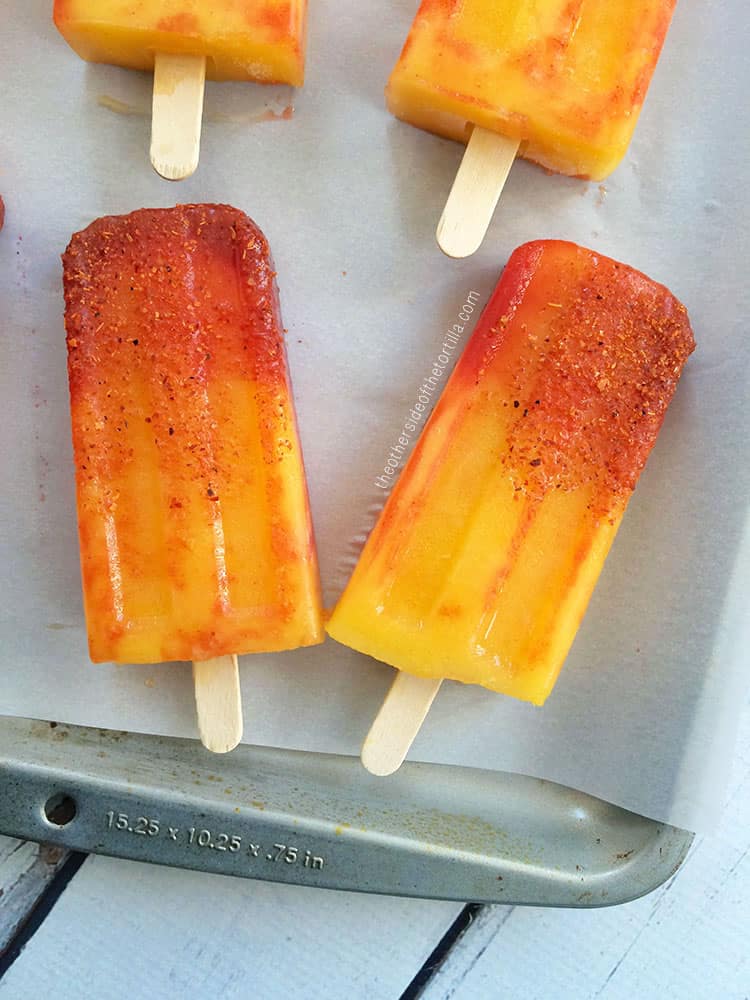 Close-up of mangonada popsicles that are red, orange and yellow