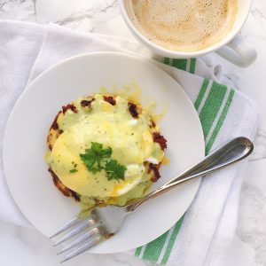 How to make Mexican eggs benedict with an ancho hollandaise, and topped with Herdez guacamole salsa. Recipe via theothersideofthetortilla.com