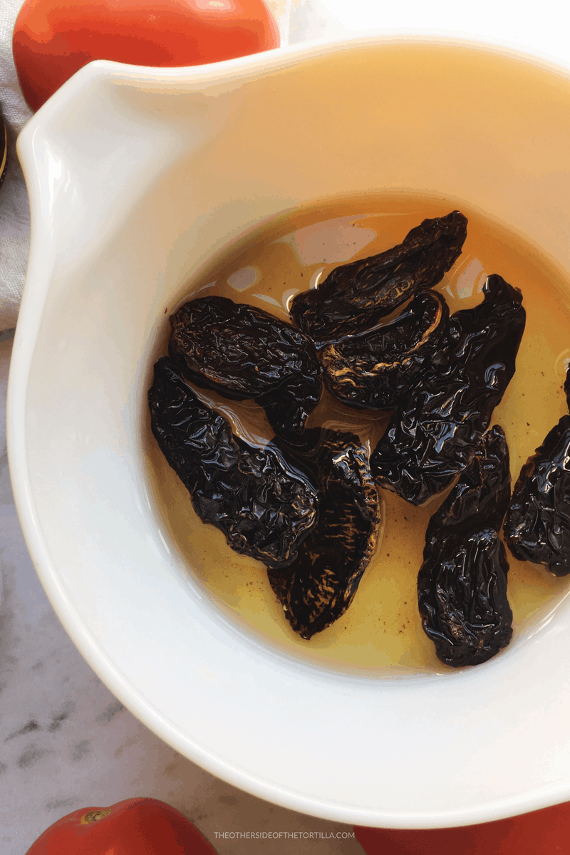 Rehydrating dried chile morita for chicharrón guisado via theothersideofthetortilla.com