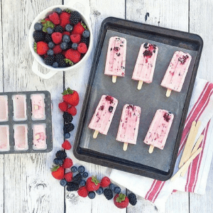 Berries and cream popsicles are a mixed-berry spin on the traditional Mexican fresas con crema dessert. Recipe via theothersideofthetortilla.com