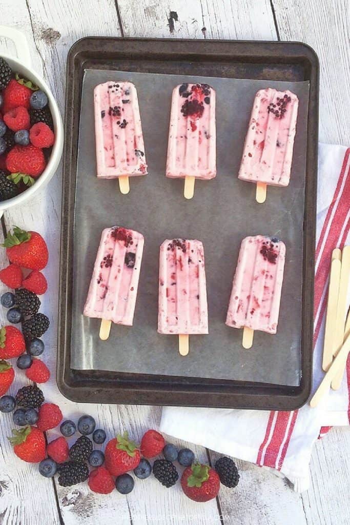 Berries and cream popsicles are a mixed-berry spin on the traditional Mexican fresas con crema dessert. Recipe via theothersideofthetortilla.com