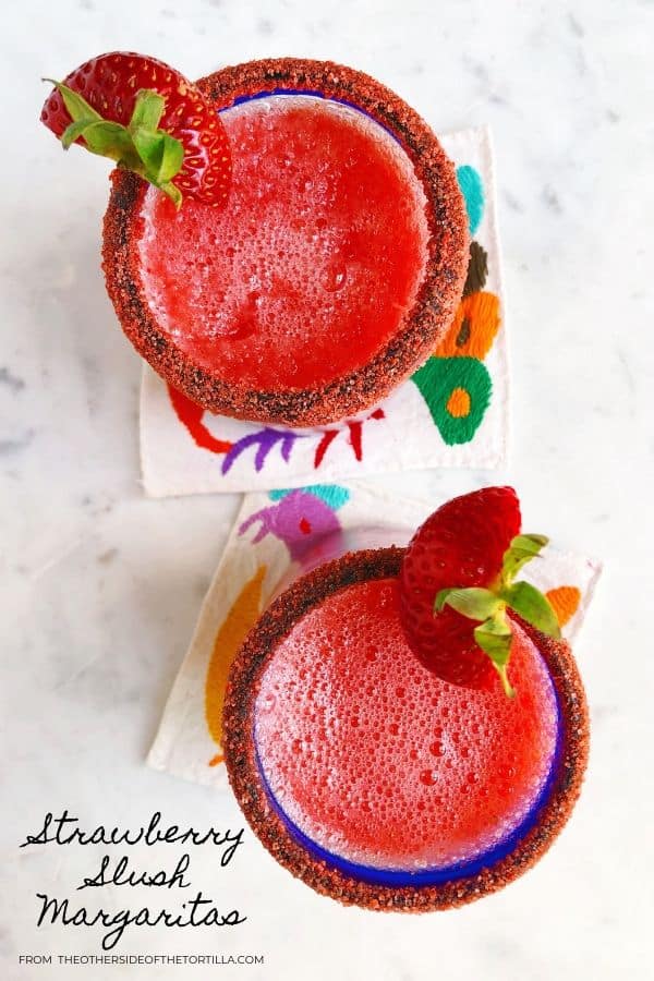 Slushy strawberry margaritas on cloth coasters