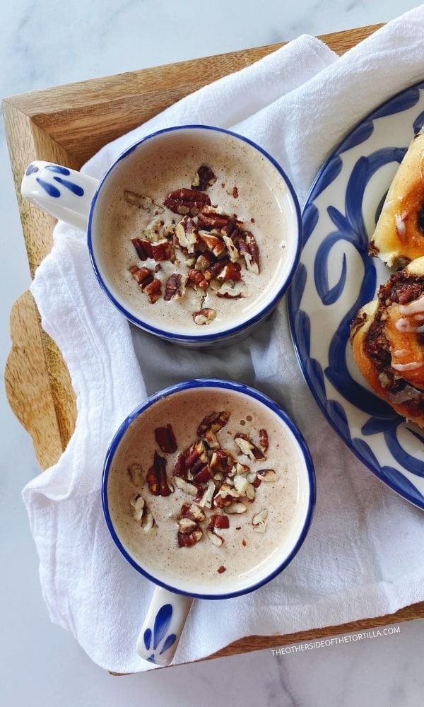 two mugs of atole de nuez on a tray