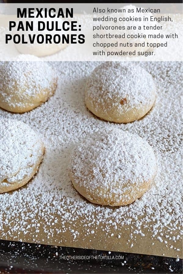 Mexican wedding cookies on a baking sheet, sprinkled with powdered sugar