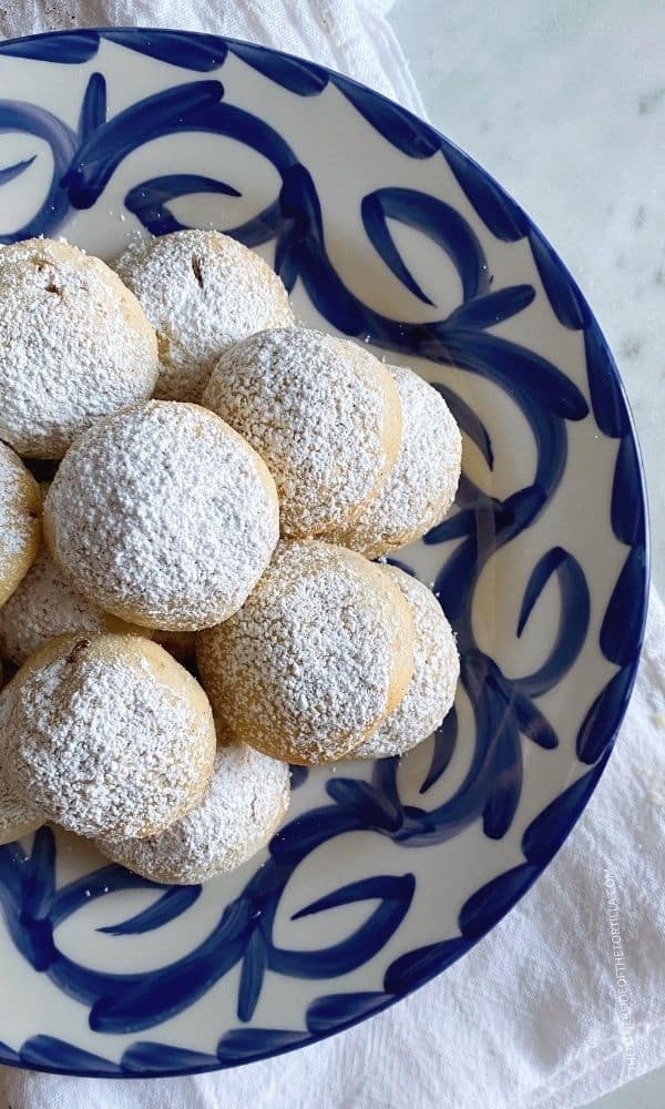 Mexican wedding cookies known as polvorones on a blue and white talavera pottery plate